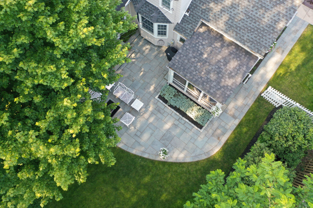 Aerial view of custom stone patio and landscaped backyard designed by Lattimer Outdoor Living Spaces in Western New York
