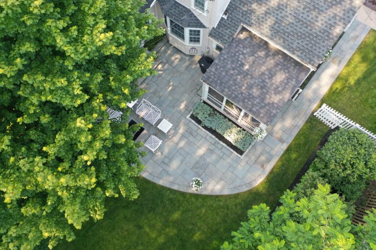 Aerial view of custom stone patio and landscaped backyard designed by Lattimer Outdoor Living Spaces in Western New York