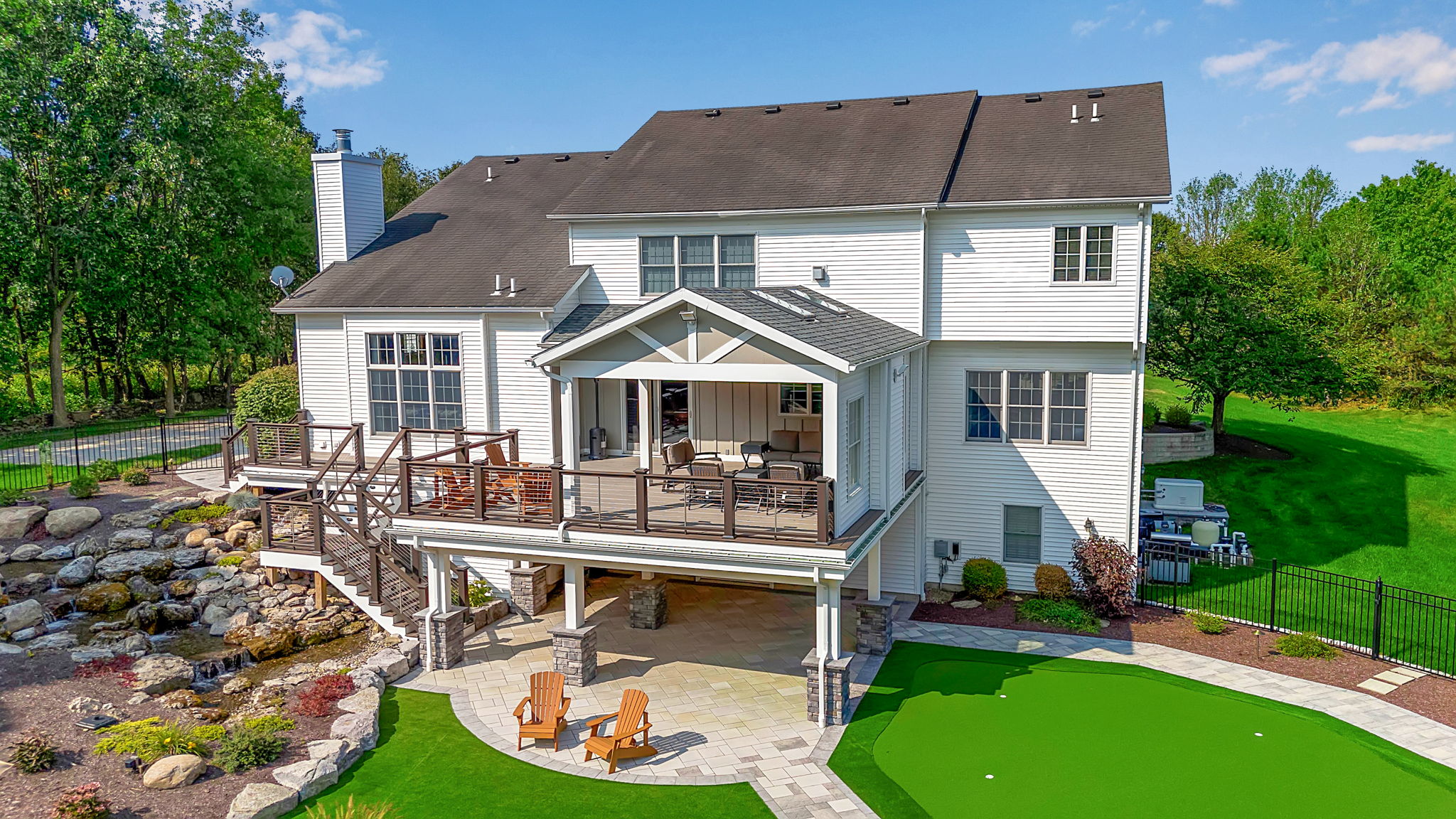 Aerial view of custom multi-level deck, pool, putting green, and outdoor living space in Clarence New York
