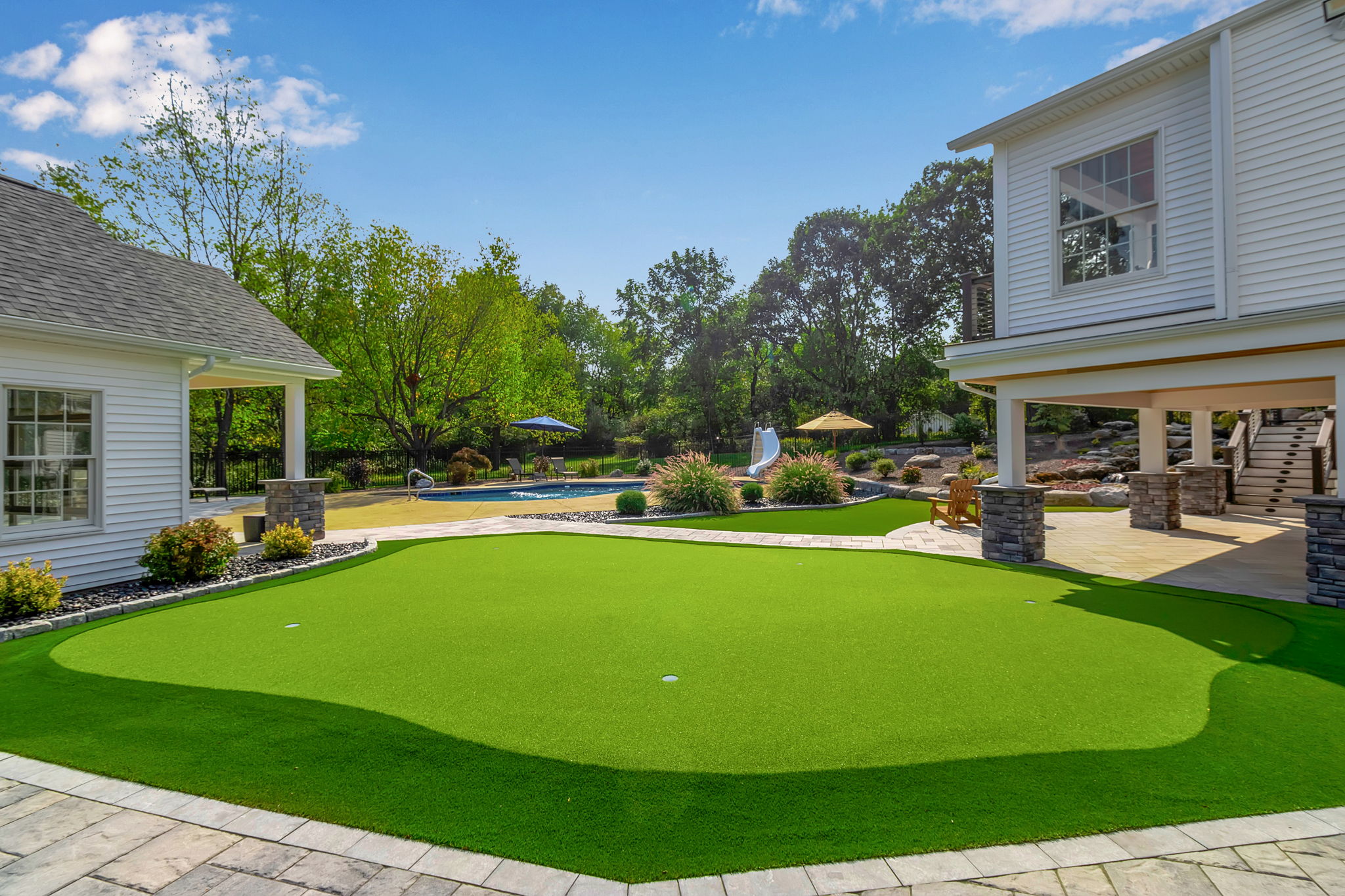Custom backyard putting green with pool and outdoor living space in Clarence New York