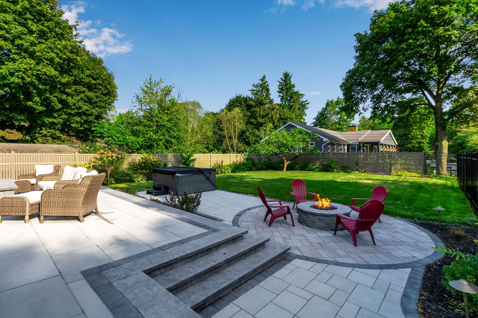 Custom backyard patio with fire pit and seating designed by Lattimer Outdoor Living Spaces in Western New York