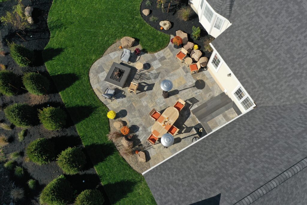 Aerial view of custom stone patio with fire pit and seating area by Lattimer Outdoor Living Spaces in Western New York