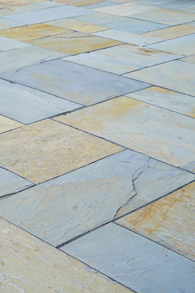 Blue-gray natural stone pavers installed in a random pattern for a custom patio