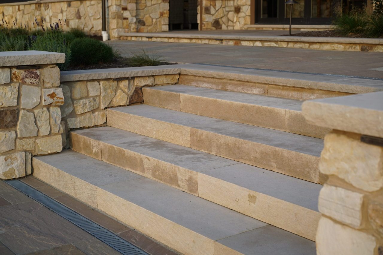 Indiana limestone steps and patio transition in custom outdoor living space in Clarence New York